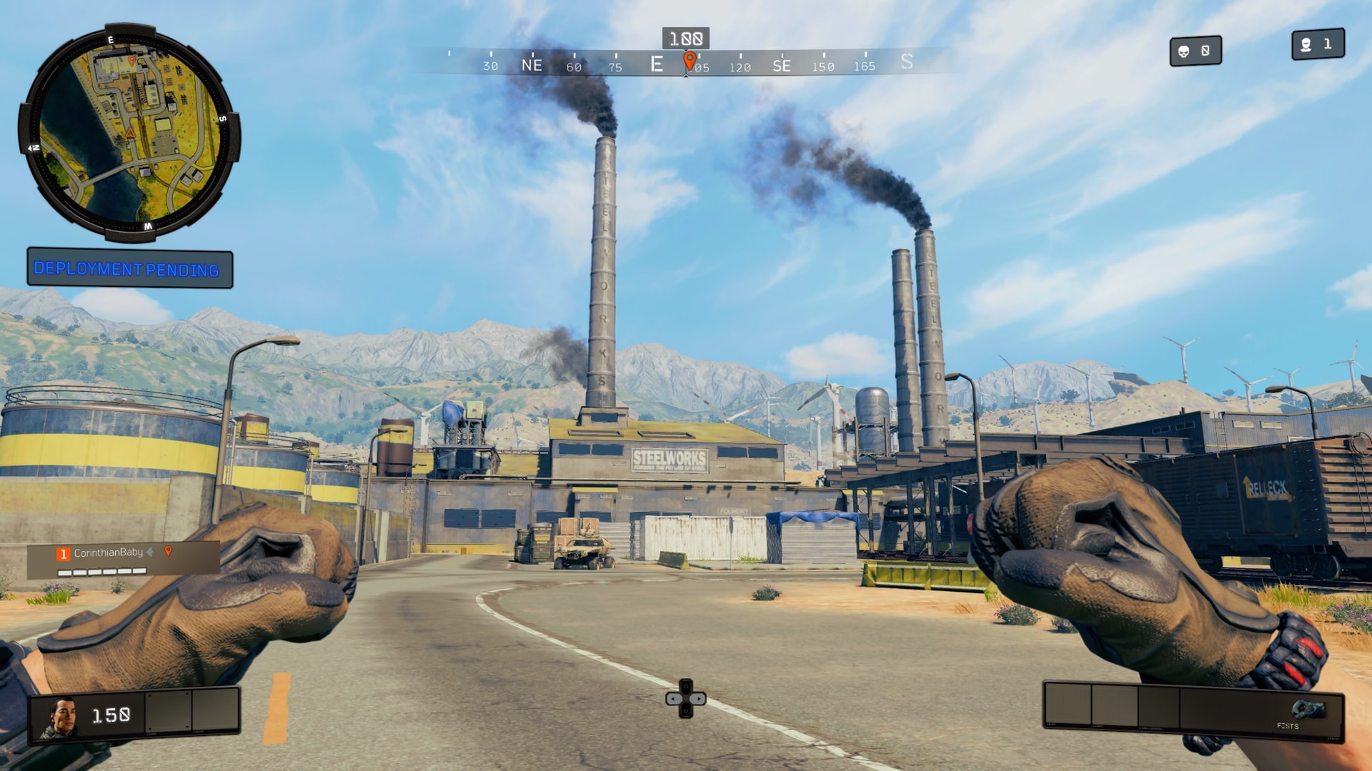 The factory’s smokestacks over a road and rail yard